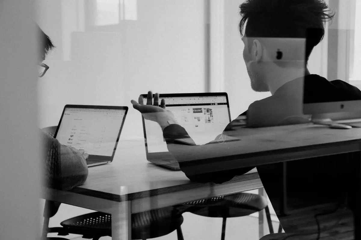 Two colleagues reviewing a website on a laptop